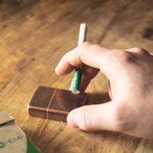 Load image into Gallery viewer, Natural CBD Cigarette held next to lighter and Wild Hemp pack